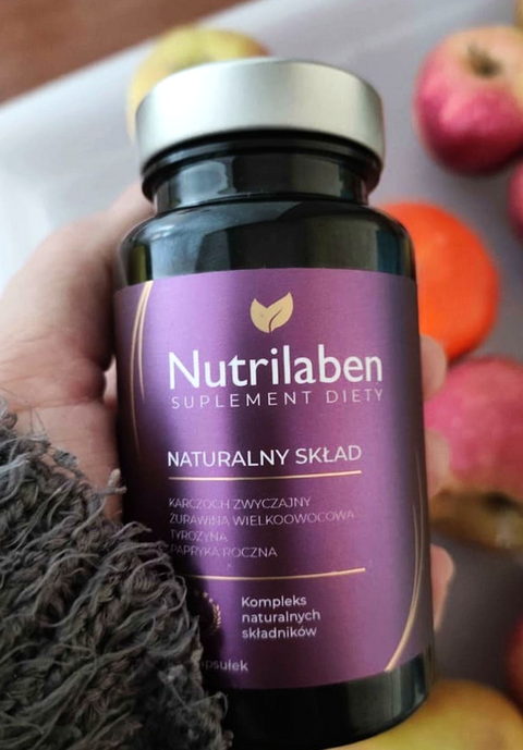 Nutrilaben obok świeżych jabłek i mandarynek na talerzu
